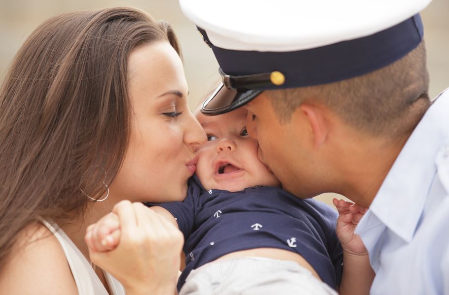 parents kissing their child